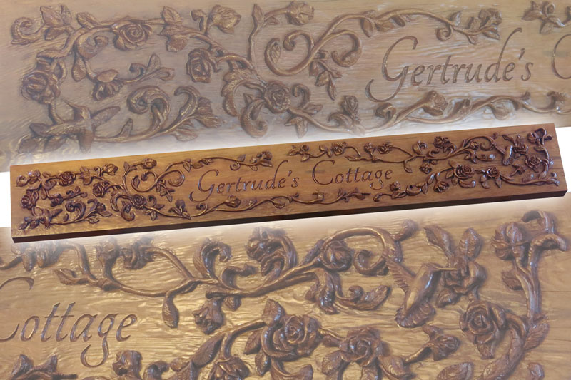 cedar sign with relief carved roses, vines, hummingbirds